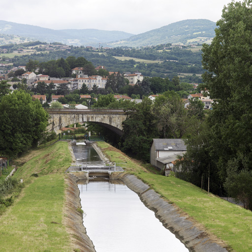 Vue du canal (partie sur la commune de Savigneux), avec le pont de chemin de fer puis Montbrison en arrière-plan.