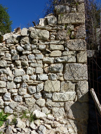 Chaîne d'angle avec pierre de taille de brèche calcaire, ruine d'une maison au village.
