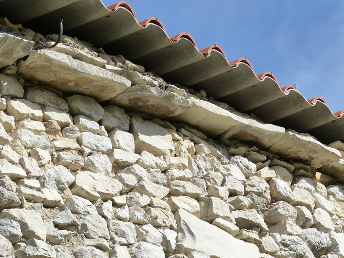 Avant-toit constitué d'un débord de lauze, ferme au village.