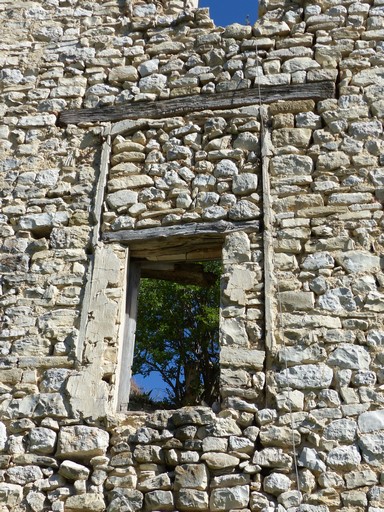 Fenêtre partiellement murée, maison au village.