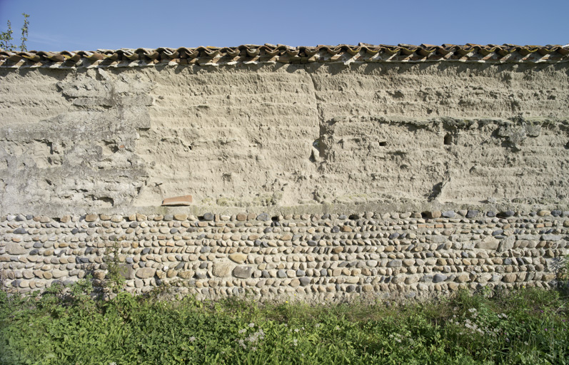Mur en pisé sur soubassement de galets (Chalain-le-Comtal, les Rayons, ferme, IA42003515).